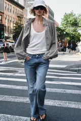 Chaqueta de manga larga con estampado de cuadros vichy en tonos marrón y blanco, cuello camisero, cierre frontal con botones y bajo ajustable con cordón.