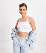 Musculosa tipo top cropped de breteles finos y escote redondo, confeccionada en tejido de punto de algodón con elastano.