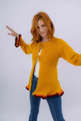 Saco de lana merino color mostaza, tejido a punto con detalle de volados en ruedo y puños. Tiene dos cierres frontales hechos en crochet a mano.
