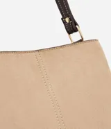 Cartera bandolera de tamaño mediano con diseño bicolor que combina paneles de gamuza sintética en color beige con laterales y correa en cuero sintético marrón oscuro. Cuenta con asa larga ajustable y tres compartimentos internos para organización.