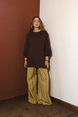 Pantalón de corte holgado y tiro medio, con estampado de cuadros grandes en tonos bordó y violeta. Cuenta con cintura elástica con cordón ajustable y bolsillos laterales.