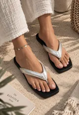 Sandalias planas tipo chancleta con base marrón de punta cuadrada y tiras anchas en color blanco.