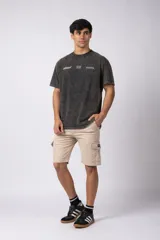 Bermuda cargo de gabardina con bolsillos laterales amplios con solapa y broche metálico. Presenta cintura con pasadores para cinturón y etiqueta tejida decorativa en uno de los bolsillos.