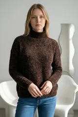 Sweater de cuello alto tipo polera, confeccionado en tejido de chenille con textura de relieve tipo waffle. Presenta mangas largas con puños acanalados y ruedo también acanalado.