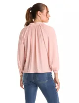Blusa de gasa con plisado soleil, cuello a la base fruncido con escote en V regulable mediante lazos, y mangas largas abullonadas con puños sastreros.