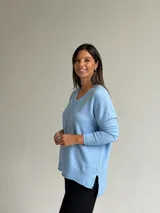 Sweater de punto color celeste, con cuello en V, mangas largas con puños acanalados y detalle de costura vertical central.