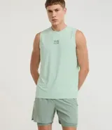 Bermuda deportiva para hombre, color verde menta, con short de compresión integrado. La bermuda exterior es suelta y tiene un pequeño logo estampado en el muslo izquierdo.