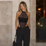 Body negro con escote halter, confeccionado en una combinación de tela opaca y encaje transparente.