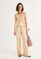 Blusa beige de tirantes finos, con escote en V y diseño fruncido tipo nido de abeja en la parte superior.