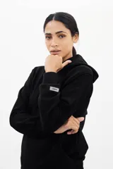 Canguro negro de algodón con frisa PIMA, corte oversized y etiqueta con logo en la manga.