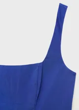 Vestido midi de color azul, sin mangas, con tirantes anchos y cuello escotado cuadrado. Presenta un diseño ajustado en el torso con corte evase y falda de corte midi con vuelo.