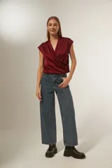 Blusa de satén color bordó, con diseño cruzado tipo sobre, cuello en V y mangas cortas integradas.