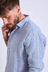 Camisa de corte regular con diseño de rayas verticales finas en tonos claros, cuello clásico y mangas largas con puños abotonados.