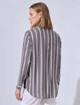 Camisa celeste con rayas verticales blancas, de corte clásico, cuello a la base, escote en V y cierre frontal con botones.