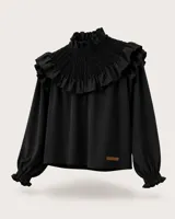 Blusa negra de manga larga con cuello alto fruncido tipo smock y amplio volante en el canesú. Cuenta con puños elásticos fruncidos y pequeña aplicación de cuero con logo en el bajo.