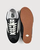 Championes Vans modelo Super Lowpro, de perfil bajo inspiradas en el diseño Serio. Presentan una combinación de ante y material sintético en color negro con detalles en blanco, incluyendo la icónica Sidestripe lateral, cordones blancos y suela de caucho con diseño Waffle.