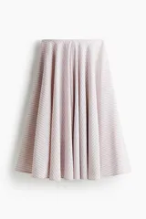 Pollera midi de corte circular en tejido jacquard, con diseño acampanado y bolsillos laterales discretos. Cuenta con cierre oculto y corchete en la parte posterior.