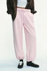 Pantalón de felpa de tiro alto con cintura elástica y corte recto. Cuenta con bolsillos laterales ocultos en la costura y bajo ajustable con cordón elástico y stoppers.