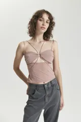 Top color marrón de malla de elastano ajustado al cuerpo, sin mangas, con recortes verticales en el frente y detalle de breteles de elástico.