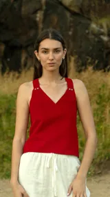 Chaleco rojo con escote en V y tirantes gruesos con botones dorados.