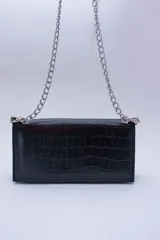 Cartera negra con textura símil cocodrilo y cadena metálica plateada.