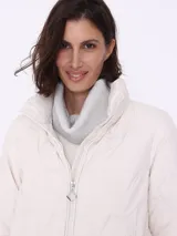 Campera puffer color crema con relleno de poliéster, cierre frontal y bolsillos laterales con cierre.