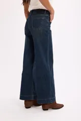 Jean de tiro alto en color azul oscuro, con costuras verticales decorativas en el frente y cierre de botón metálico.