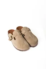 Zuecos de cuero con hebilla ajustable y base de corcho.