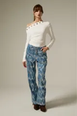 Pantalon de jean recto con acabado brillante de lentejuelas plateadas sobre base azul, de tiro medio.