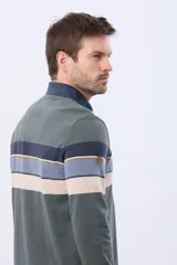 Remera polo de manga larga con diseño de rayas horizontales en tonos azul marino, marrón y gris. Presenta cuello camisero con cierre de botones y puños elásticos en las mangas.