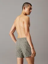Short de baño verde con estampado del logo de Calvin Klein en blanco. Tiene cintura elástica con cordón ajustable, bolsillos laterales y un bolsillo trasero.