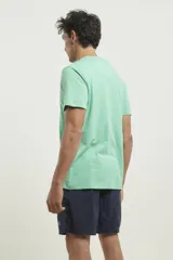 Remera verde con cuello redondo abotonado.
