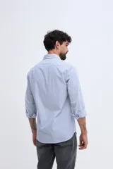 Camisa de manga larga fit semi slim color celeste, con cierre frontal de botones y cuello camisero clásico.