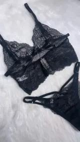 Conjunto de lencería compuesto por un bralette de encaje con breteles ajustables y una tanga de encaje con tiras laterales decorativas.