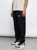 Pantalón deportivo negro de nylon con detalles en contraste blanco y logo de Umbro bordado en el lateral. Corte relajado.