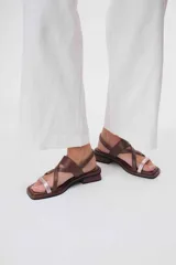 Sandalias de cuero azul con tiras cruzadas y hebilla lateral. Presenta una tira delantera color rosa claro.