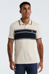 Polo de manga corta Original Penguin confeccionada en tejido interlock, color beige con franja horizontal central en azul marino y detalles en celeste. Presenta cuello clásico con botones y logo bordado en el pecho.