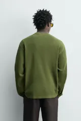 Remera de manga larga en tejido waffle de algodón color verde militar, con cuello redondo y corte relajado.