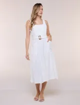 Vestido midi blanco de la marca Nina Leonard, sin mangas y con escote cuadrado. Cuenta con corte en la cintura, bolsillos laterales con solapa, falda fluida con detalle de frunce inferior e incluye un cinturón del mismo género con hebilla carey.