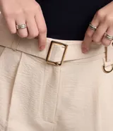 Pantalón zanahoria de mujer confeccionado en tela airflow color azul marino, con trabillas en la cintura, cinturón con hebilla, pliegues y elástico en la espalda.