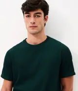 Remera de manga corta y cuello redondo, confeccionada en tejido de media malla con textura vertical. Presenta un diseño minimalista y versátil, ideal para un look casual.