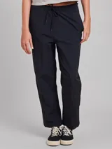 Babucha de estilo deportivo en color negro, confeccionada en tejido ligero con acabado texturizado. Presenta cintura elástica con cordón ajustable y corte holgado.