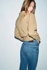 Jeans de tiro alto con corte mom fit, diseño de cinco bolsillos y raya planchada frontal. Presenta cierre frontal con cremallera y botón.