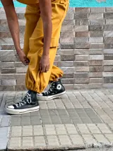 Conjunto de dos piezas compuesto por un top sin mangas con escote en V y un pantalón tipo babucha cargo con cintura elástica, bolsillos laterales y puños ajustables en los tobillos.