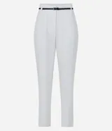 Pantalón carrot negro de sastrería, con bolsillos, pliegues y cinturón fino de cuero sintético.