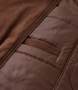 Campera bomber de pana color marrón, con cuello polo, cierre frontal con cremallera y puños y bajo elásticos.