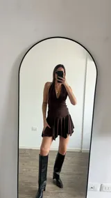 Vestido corto blanco con escote halter y falda con volados.