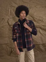 Overshirt de polar con estampado de cuadros en tonos rojos, azules y beige. Presenta cuello clásico, cierre frontal con botones, bolsillos en el pecho y mangas largas con puños acanalados.