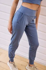 Pantalón tipo babucha de tiro alto, con cintura elástica ancha, bolsillos laterales y puños ajustados en los tobillos.