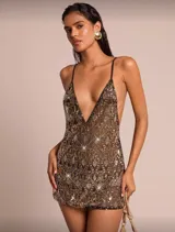 Vestido corto negro con bordados dorados y lentejuelas, escote en V profundo y breteles finos. Espalda descubierta.